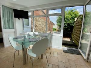 a dining room with a glass table and chairs at The Gables in Sidmouth