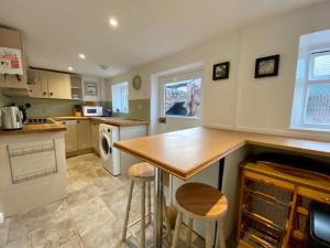 a kitchen with a table and two stools at Cloud Nine in Otterton