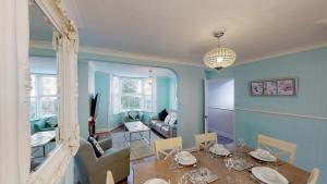 een eetkamer met een tafel en een woonkamer bij Bethany Cottage in Sidmouth