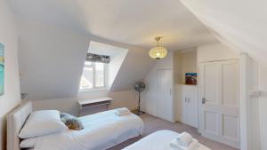 ein Schlafzimmer mit zwei Betten und einem Fenster in der Unterkunft Bethany Cottage in Sidmouth + 14 Fotos