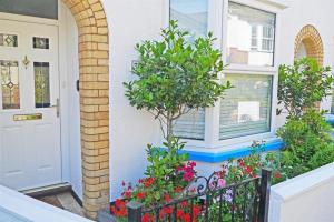 a front door of a house with flowers at Bethany Cottage in Sidmouth
