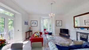 uma sala de estar com um sofá vermelho e uma televisão em 2 Claremont em Sidmouth
