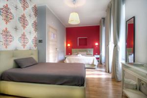 een slaapkamer met 2 bedden en een rode muur bij Sweet Home Faleria in Rome