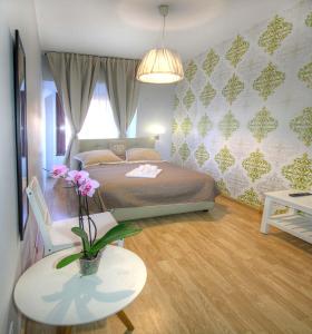 een slaapkamer met een bed en een tafel met een vaas met bloemen bij Sweet Home Faleria in Rome