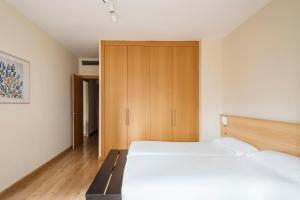 una camera con 2 letti e un armadio di Barcelona Apartment Villarroel a Barcellona