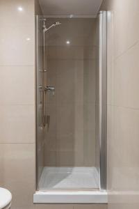 バルセロナにあるバルセロナアパートビジャのバスルーム(ガラスドア付きのシャワー付)