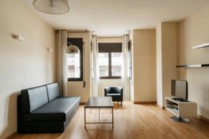 a living room with a couch and a tv at Barcelona Apartment Villarroel in Barcelona