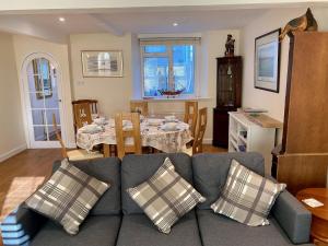 ein Wohnzimmer mit Couch und ein Esszimmer in der Unterkunft Buttercup Cottage in Sidmouth