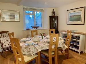 ein Esszimmer mit einem Tisch mit Stühlen und einem Tisch in der Unterkunft Buttercup Cottage in Sidmouth + 16 Fotos