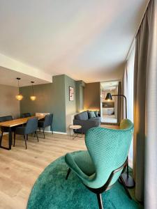 uma sala de estar com uma cadeira verde e uma mesa em zeitwohnhaus SUITE-HOTEL & SERVICED APARTMENTS em Erlangen