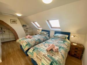 1 Schlafzimmer mit 2 Betten in einem Zimmer mit Oberlichtern in der Unterkunft Buttercup Cottage in Sidmouth