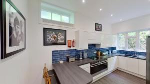 Una cocina con gabinetes blancos y una mesa de madera. en 1 Claremont, en Sidmouth