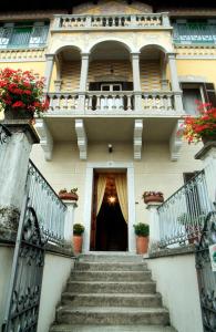 Eine Treppe führt zu einem Gebäude mit einem Balkon. in der Unterkunft Hotel La Rondinella in Cannero Riviera