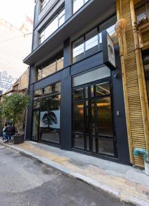a black building with glass windows on a street at The Fountain Athens in Athens