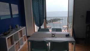 Un comedor con mesa y vista al mar. en BeachFront, en Giardini Naxos