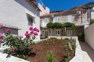 
a garden filled with plants and flowers in front of a building at Apartments Aurelia in Dubrovnik
