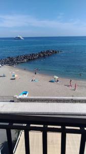 una playa con gente en la arena y el agua en BeachFront, en Giardini Naxos