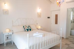 a bedroom with a white bed and a crib at Almasarda in Olbia