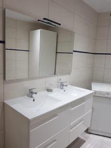biała łazienka z umywalką i lustrem w obiekcie Surf w mieście Estepona