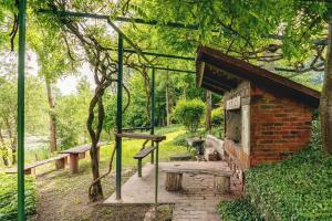 a brick building with a bench and a picnic table at Rajski vrt - Lake house - Paradise garden in Sisak
