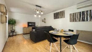 sala de estar con mesa y sofá en HOMEY WOOD - New - Appartement avec une chambre - Parking privé gratuit - Balcon privé - A 5 min de la gare pour rejoindre Genève en Annemasse