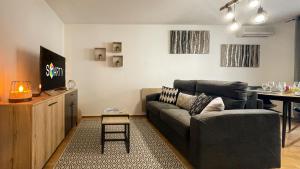 sala de estar con sofá y mesa en HOMEY WOOD - New - Appartement avec une chambre - Parking privé gratuit - Balcon privé - A 5 min de la gare pour rejoindre Genève en Annemasse