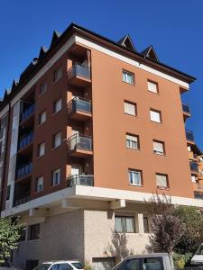 un edificio alto con macchine parcheggiate di fronte di APARTAMENTO MUY CÉNTRICO con VISTAS - El Niuet de Sort a Sort