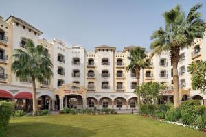 a large building with palm trees in front of it at Crowne Plaza Riyadh Al Waha by IHG in Riyadh