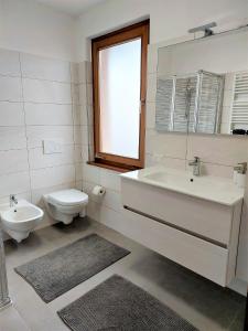 a white bathroom with a sink and a toilet at Casa Edda in Malcesine +31 photos