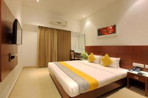 a hotel room with a bed and a television at Hotel Park Residency Kuttiyadi in Kuttyādi