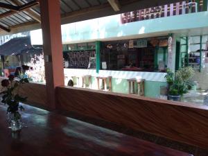 a bar in a restaurant with a counter with stools at Coco Grove Pension and Beach Resort in Sindangan