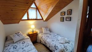2 camas individuais num quarto no sótão com um telhado em APARTAMENTO MUY CÉNTRICO con VISTAS - El Niuet de Sort em Sort