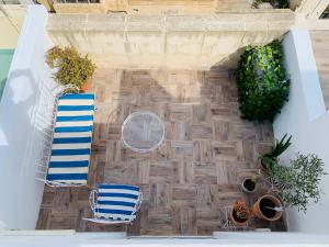 a patio with two chairs and potted plants at Anthony's Sea Stay in Marsaxlokk