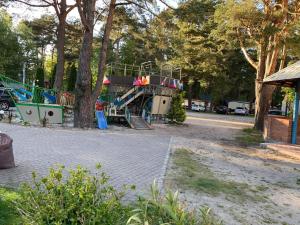 a playground with a slide in a park at Letnisko Dębki in Dębki