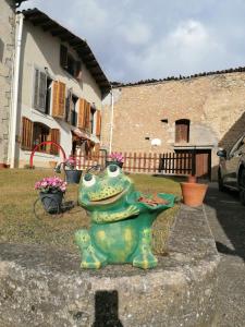 a green frog statue sitting on top of a wall at Casa centro Gósol in Gósol