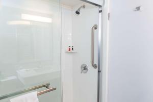 y baño con ducha y puerta de cristal. en Studio 6 Ocala, FL, en Ocala