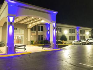 un edificio con luces azules en un aparcamiento en Studio 6 Suites Tupelo, MS, en Tupelo