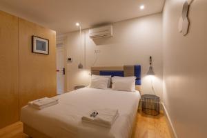 Un dormitorio con una cama grande con sábanas blancas. en ORM - Almada Balcony Apartment, en Oporto