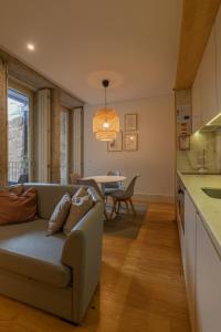 una sala de estar con un sofá y una mesa en ORM - Almada Balcony Apartment, en Oporto