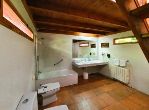 Un baño con bañera, lavabo y ducha. en La Posada, en Llanes 37 fotos más
