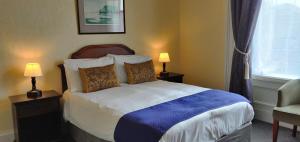 - une chambre avec un lit, deux lampes et une fenêtre dans l'établissement Hartfell Guest House, à Moffat