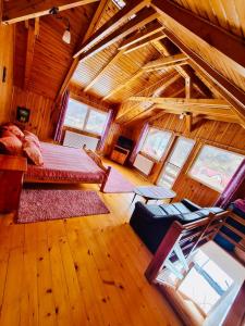 una grande camera con un letto in una mansarda in legno di Cabana Vânătorilor a Poiana Mărului