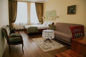 una sala de estar con un sofá y una cama en Aparthotel Grodzka 21, en Cracovia