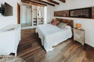 a bedroom with a bed and a television on the wall at Posada del tiempo in Villavieja del Lozoya