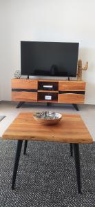 mesa de centro de madera con TV de pantalla plana en la parte superior en Appartement Standing au coeur d'Albufeira, en Albufeira