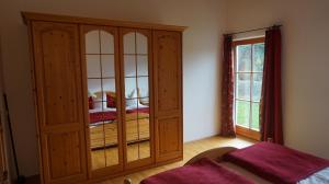 Un dormitorio con un gran armario de madera y una cama en Hölzlhof, en Amerang