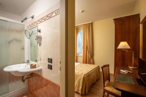 a hotel room with a sink and a bed at Hotel Verdeborgo in Grottaferrata