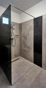 a bathroom with a shower with a glass door at Comfort Ház in Balatonőszöd