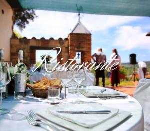 una mesa con un mantel blanco con un cartel que diga excelencia en Agriturismo Poggio La Buca, en Civitella Marittima