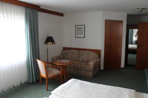 a hotel room with a couch and a table and a chair at Haus Im Garten in Köngen